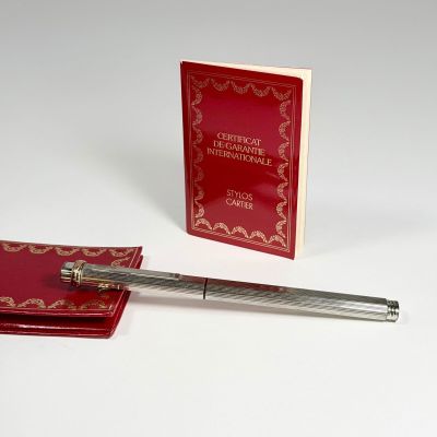 un stylo posé à côté d'un livre et un stylo sur une table