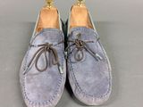 a pair of blue sued shoes with brown laces on them