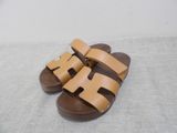 tan leather sandals with two straps and a buckle on each side