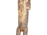 statue of a man with a hat on his head standing on a wooden base