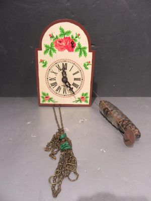 une horloge à laquelle est attachée une chaîne, à côté d'un briquet