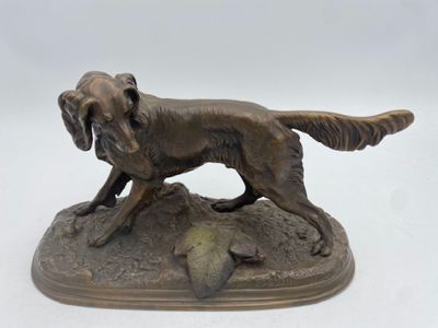 statue of a dog on a rock with a bird in its mouth