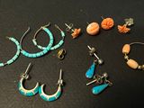 several pairs of earrings and bracelets are sitting on a table