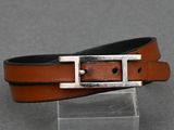 un gros plan sur une ceinture en cuir marron dotée d'une boucle argentée