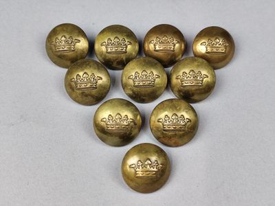 six boutons en laiton ornés de couronnes sur un fond blanc