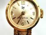 an image of a close up of a wrist watch with a chain around it
