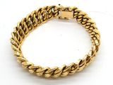 un bracelet en or jaune présentant un motif tressé sur fond blanc