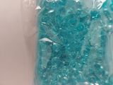 a bag of blue beads sitting on a white surface