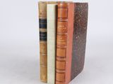 trois livres sont empilés sur une surface blanche