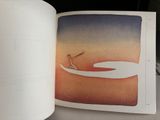 an open book with a picture of a person on a surfboard