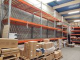 Les cartons sont empilés sur des palettes dans un entrepôt au toit bleu