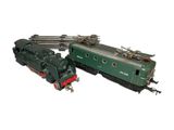 a green and red train engine next to a green and red train car