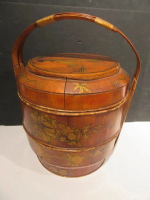 a small wooden basket with a handle on a table