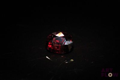 a close up of a red diamond on a black surface
