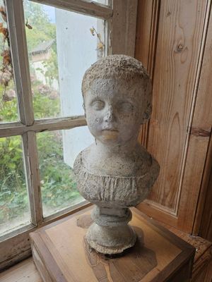 une statue représentant une femme assise sur une table en bois