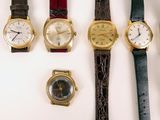 several different types of watches are lined up on a white surface