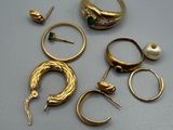 beaucoup de bagues et de boucles d'oreilles en or posées sur une table