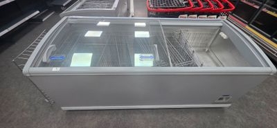 a display case in the middle of a store filled with food