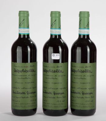trois bouteilles de vin posées les unes à côté des autres sur une surface blanche