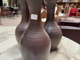 three vases sitting on a marble table in a store