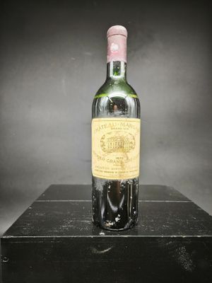 une vieille bouteille de vin posée sur une boîte noire