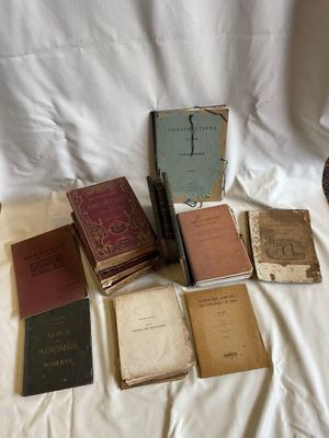de nombreux livres anciens posés sur un drap blanc, sur un lit
