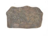 a metal plaque with asian writing on it on a white surface