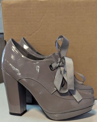 chaussures à talons hauts grises ornées d'un nœud noué autour de la pointe