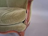 a chair with a green velvet upholstered and a wooden frame