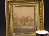 une tasse et une soucoupe posées à côté d'un cadre photo