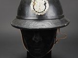 an old helmet with a badge on it sitting on top of a mannequin head