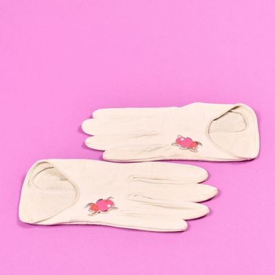 une paire de gants blancs sur fond rose