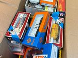 a cardboard box full of toy trains and other toys