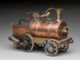 a small metal train with a copper engine on it