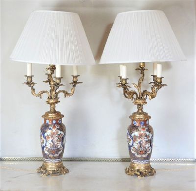 pair of antique lamps on a table with white lampshads