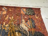 a tapestry with a picture of a man riding a horse