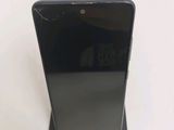 the back of a black cell phone sitting on top of a white table