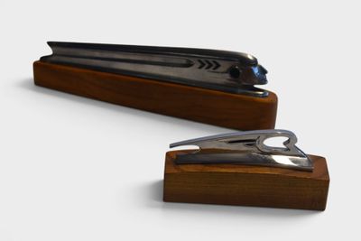 a stapler and a pair of scissors on a wooden stand