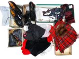 Plusieurs paires de chaussures et des vêtements se trouvent dans une boîte posée sur une surface blanche.