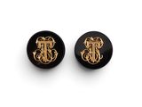 une paire de boucles d'oreilles noires et dorées ornées d'un monogramme