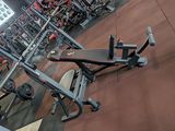 a gym with a bench and weights in the middle of the room