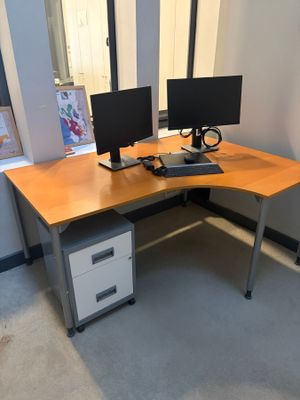 a desk with two monitors and a keyboard on it