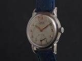 a close up of a wrist watch with a blue strap