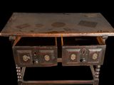 an old wooden table with two drawers on it
