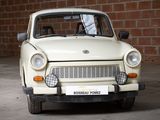 a small white car parked in front of a brick wall