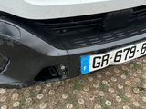the front bumper of a white truck with a number plate on it