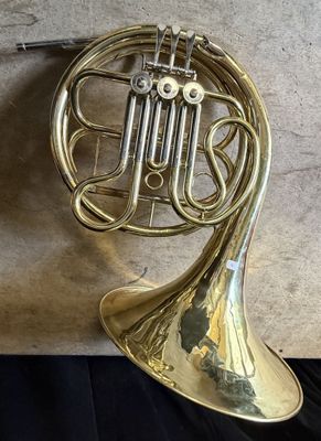 an antique brass french horn sitting on top of a black table