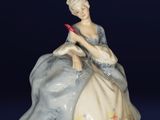 une figurine de femme assise sur une chaise
