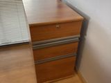 a wooden desk with a drawer in front of a window