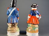 pair of figurines of two men dressed in military uniforms